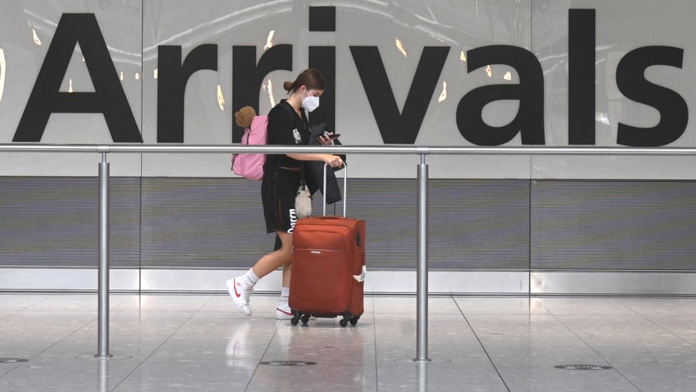 Passenger in face mask in airport arrivals hall