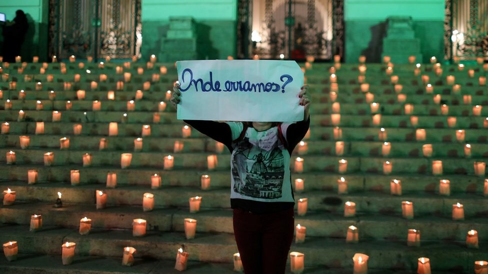 A protester against the government's policies holds a placard saying, "Where did we go wrong?"