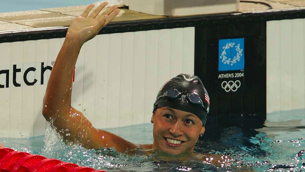 Dr Tara Kirk Sell waving at one end of a swimming pool