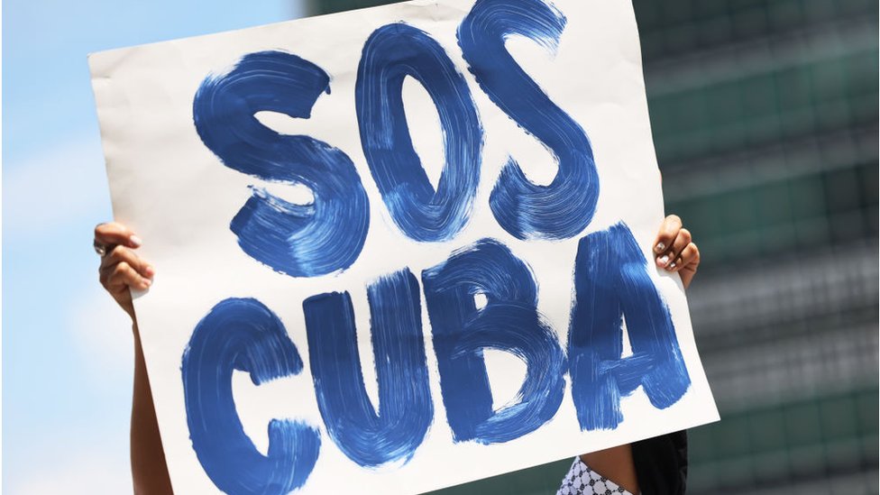 Protester carries a SOS Cuba placard during a rally in New York