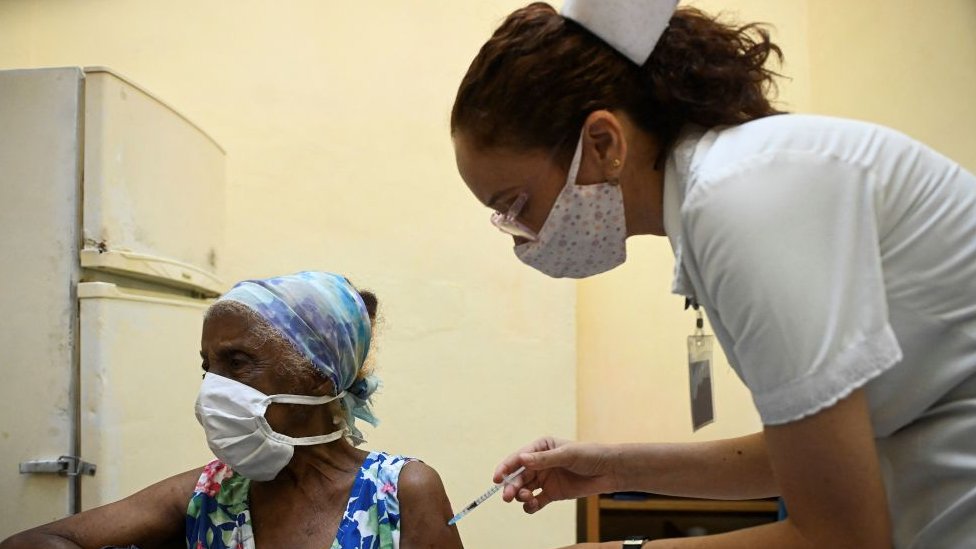 Korona virus i Kuba: Zemlja koja je slala lekare u inostranstvo, a sad joj preti kolaps zdravstva zbog Kovida-19 6 A nurse vaccinates an elderly woman against COVID-19 with Cuban vaccine Abdala in Havana, on August 2, 2021