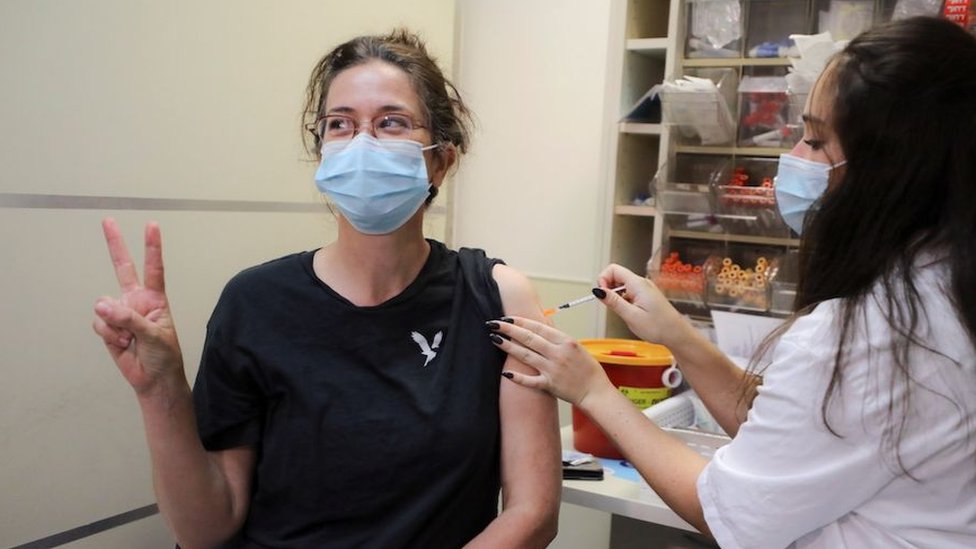 Korona virus i vakcinacija: Da li treća doza daje pravu zaštitu i da li je moralno nuditi ih sada 1 An Israeli woman poses for a picture as she receives a third shot of coronavirus disease (COVID-19) vaccine as country launches booster shots for over 40-year-olds, in Jerusalem August 20, 2021.