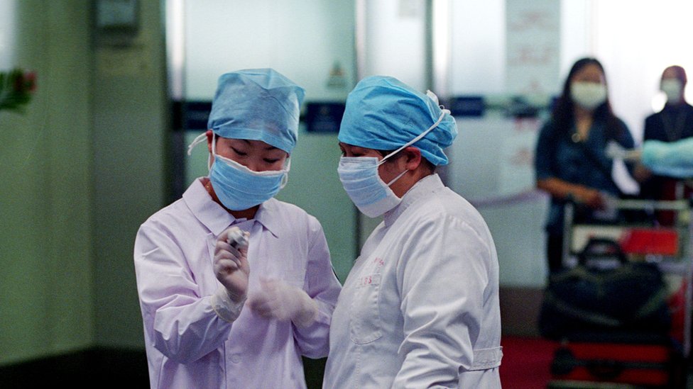 Korona virus i najčešća pitanja: Sve što ste hteli da znate o Kovidu-19 17 Nurses check a thermometer reading in the departure hall of the Beijing's Capital Airport April 28, 2003
