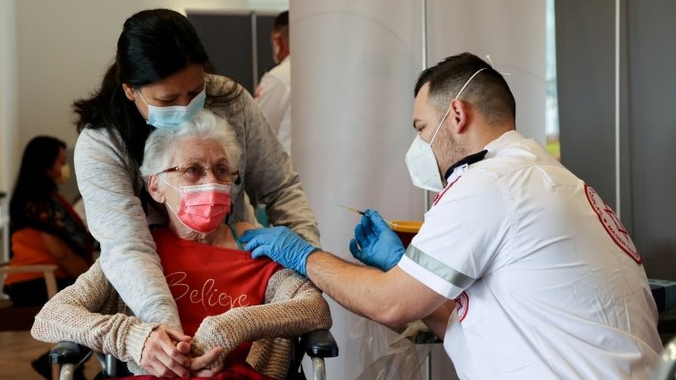 An elderly woman (centre) is vaccinated in Netanya, Israel. File photo