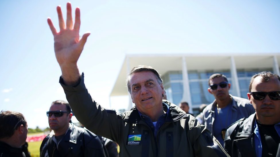 Brazil's President Jair Bolsonaro gestures to the crowd at a motorcade rally