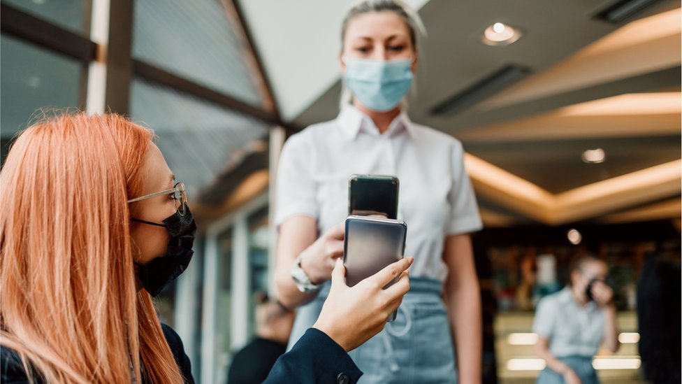 Korona virus: Broj preminulih i dalje visok u Srbiji, Holandija od danas u novom režimu mera, Izrael se zatvara za strance 6 A waitress scans a Covid pass