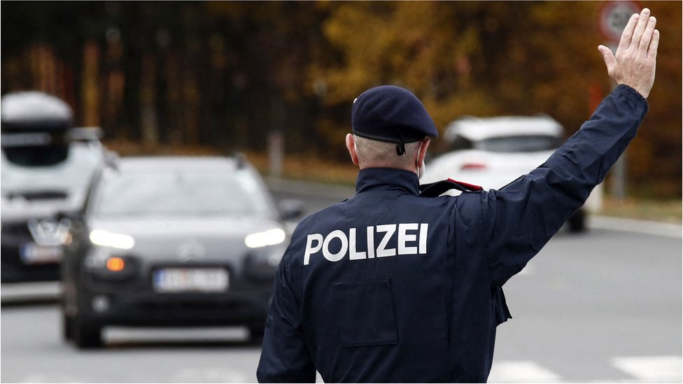 Korona virus i Austrija: Kako dijaspora živi pod novim merama - „Beč je podeljen grad na vakcinisane i nevakcinisane" 2 An Austrian police officer gestures towards car drivers at a traffic control point in Klagenfurt, Austria