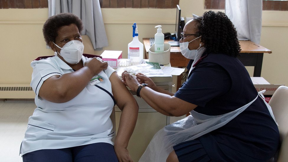 A nurse gets a temperature check before receiving a dose of the Johnson & Johnson vaccine against the COVID-19 coronavirus as South Africa proceeds with its inoculation campaign