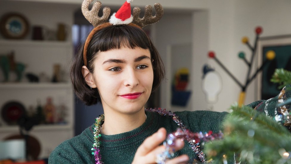 Doček Nove godine, Srbija i region: Od koncerata, preko performansa i zabrana, do lutrije - koliko će koštati novogodišnja noć 5 Woman decorating Christmas tree