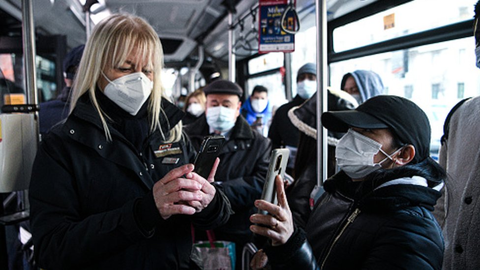Korona virus: Pada broj novozaraženih u Srbiji, postojeće vakcine štite od omikron soja - kažu iz SZO 1 An official checks Covid-19 health passes of passengers on a bus in Italy