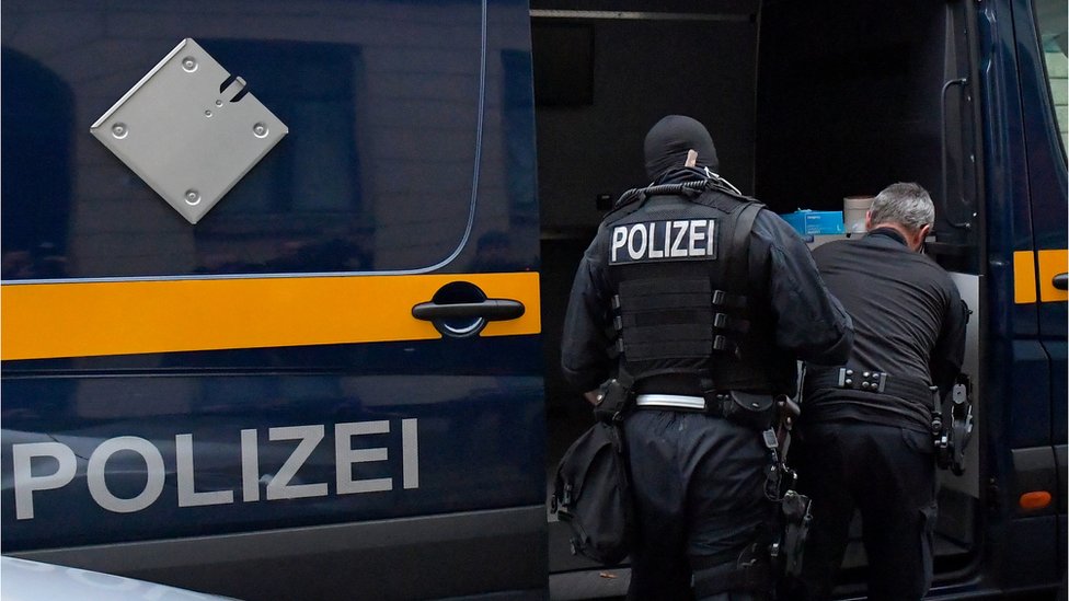 Nemačka i korona virus: Policijska racija u Drezdenu zbog sumnji da je antivakserska grupa htela da ubije premijera Saksonije 1 Police in front of a vehicle during raids in several locations in Dresden, Germany, December 15, 2021