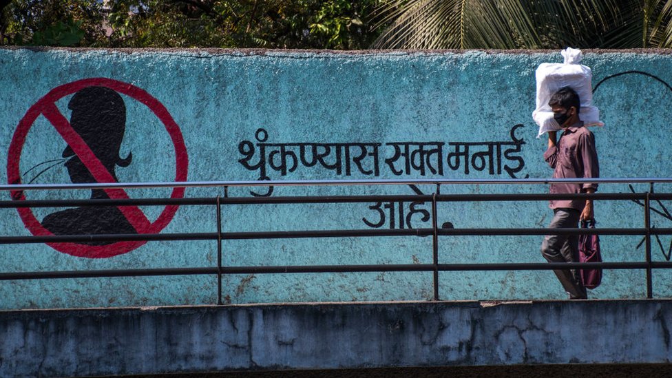 Korona virus i Indija: Borba protiv odvratne navike pljuvanja na ulicama - rat koji se teško dobija 5 A man wears mask as a protection from corona virus walk pass next to the no spitting message on the wall at Marinelines, on March 18, 2020 in Mumbai, India.