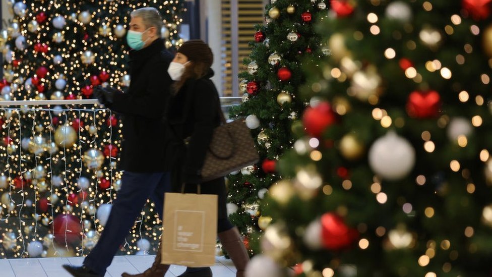 Korona virus: Pritvoren muškarac u Sloveniji koji se sedam puta vakcinisao u ime drugih, Evropa uvodi strože mere zbog omikron soja 1 Two people Christmas shopping in Germany