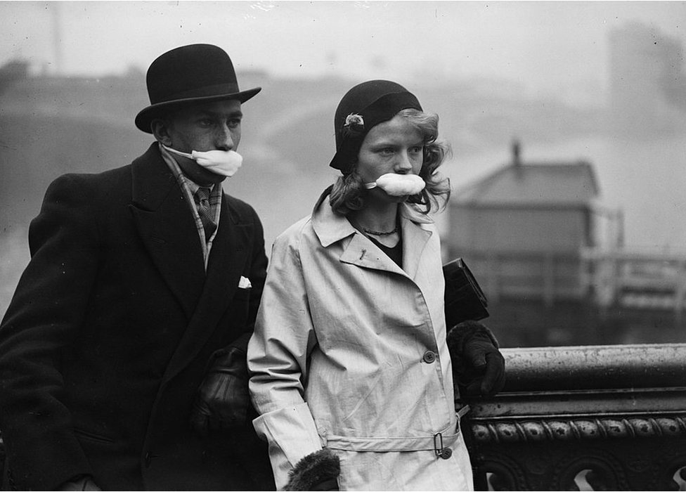 Pedestrians in a London street wearing masks over their mouths