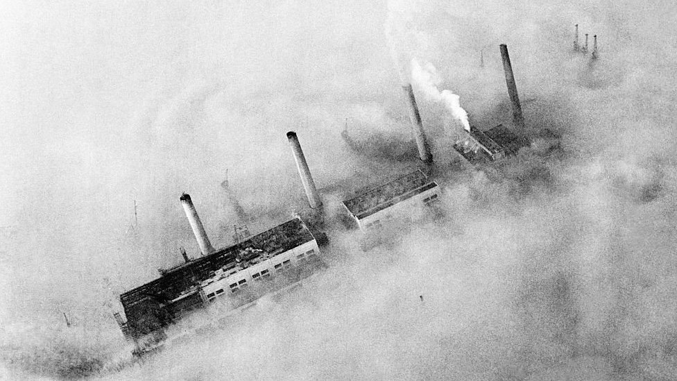 Chimneys of an East End factory poke through the blanket of smog covering London. Circa 1952