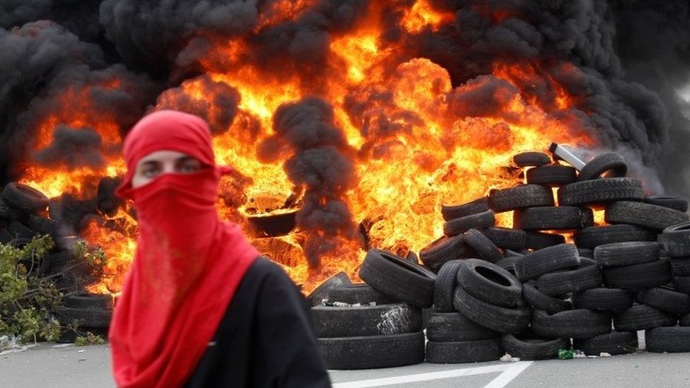 Politika, privreda i korona virusa: Od novog američkog predsednika do plana za spas planete - šta je obeležilo 2021. godinu 3 A protester stands in front of blazing tyres in Montegro
