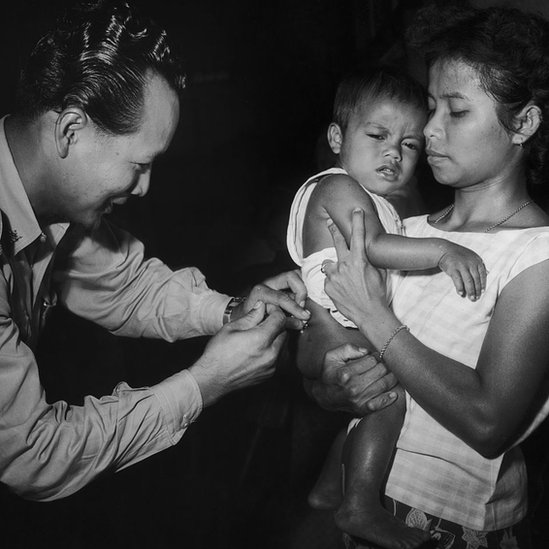 Korona virus i vakcina: Kako su antivakcinaši vršili uticaj na svet kroz istoriju 32 A man administers a vaccine to a toddler held by a woman