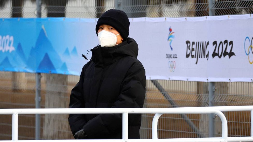 Zimske olimpijske igre: Kako izgleda kineska kovid politika i da li radi 1 A security person stands guard outside the main press centre inside a closed loop area in Beijing