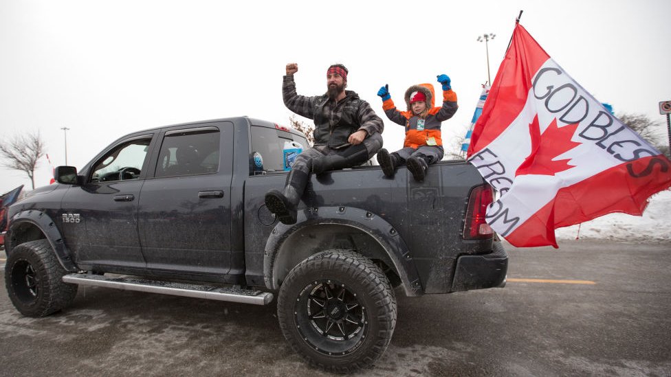 Korona virus, protesti i Kanada: Premije Trudo kaže da nema govora o slanju vojske na kamiondžije 1 A man and child sit a top the back of a pick up truck which was participating in the convoy.