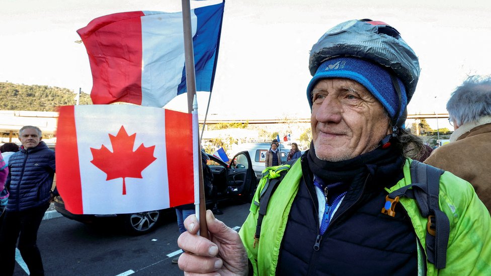 Korona virus. Kanada i Francuska: Vlasti u Parizu zabranile Konvoj slobode, u Kanadi blokade zaustavile rad automobilskih fabrika 1 A man holds a stick with the Canada and France flags