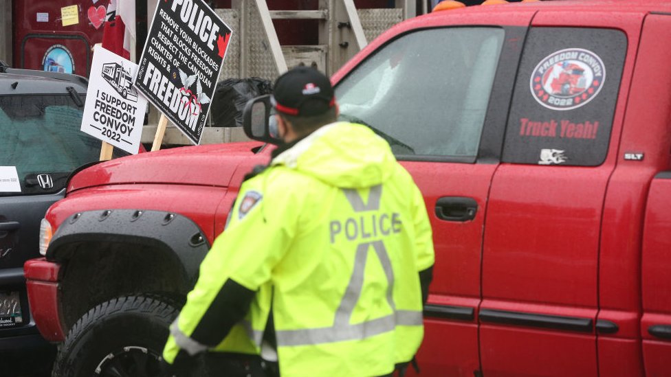 Korona virus i Kanada: Uhapšene vođe protesta, počelo zamrzavanje bankovnih računa demonstranata 2 Ottawa Police hand out papers telling the truckers to leave or face arrest