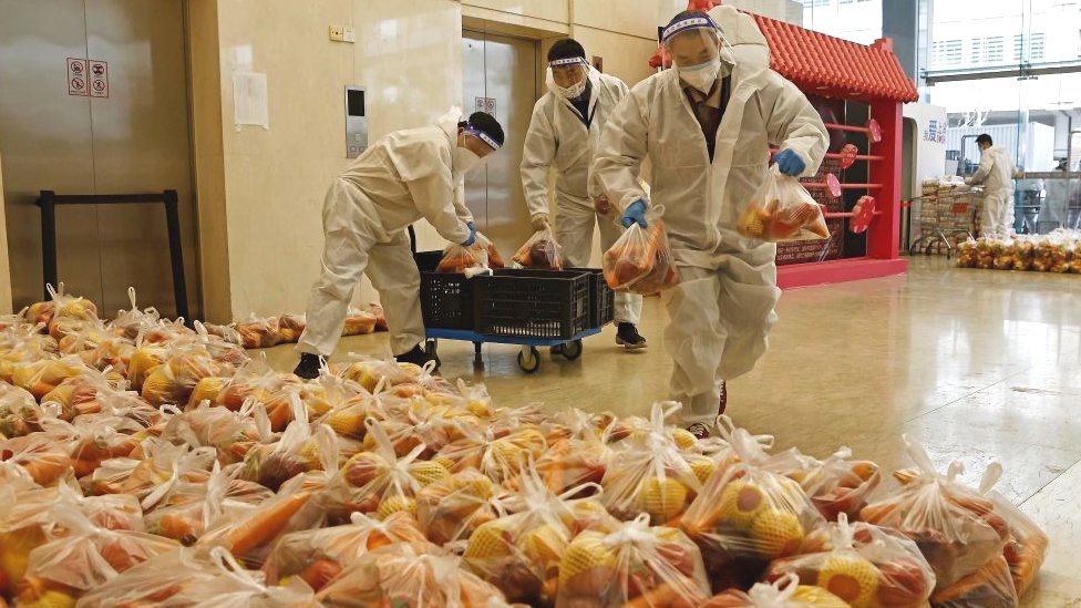Korona virus i Kina: Muke zaključanih zbog kovida u Šangaju: Sve je manje hrane 3 Workers transport supplies to a temporary warehouse at a football field in Shanghai on April 5, 2022