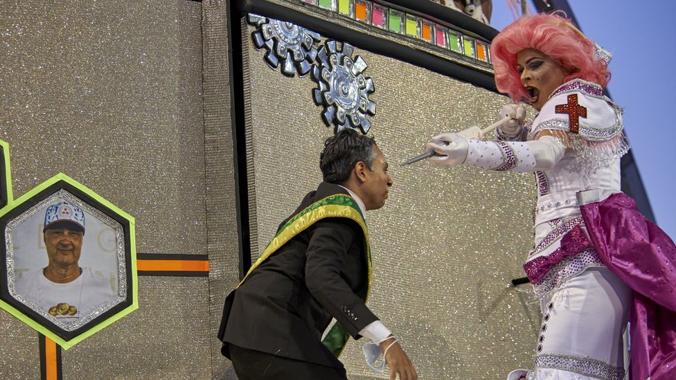 Korona virus i Brazil: Predsednik Bolsonaro ismejan na karnevalu - pretvorili ga u krokodila 2 A man dressed as a president being jabbed by a person dressed as a nurse