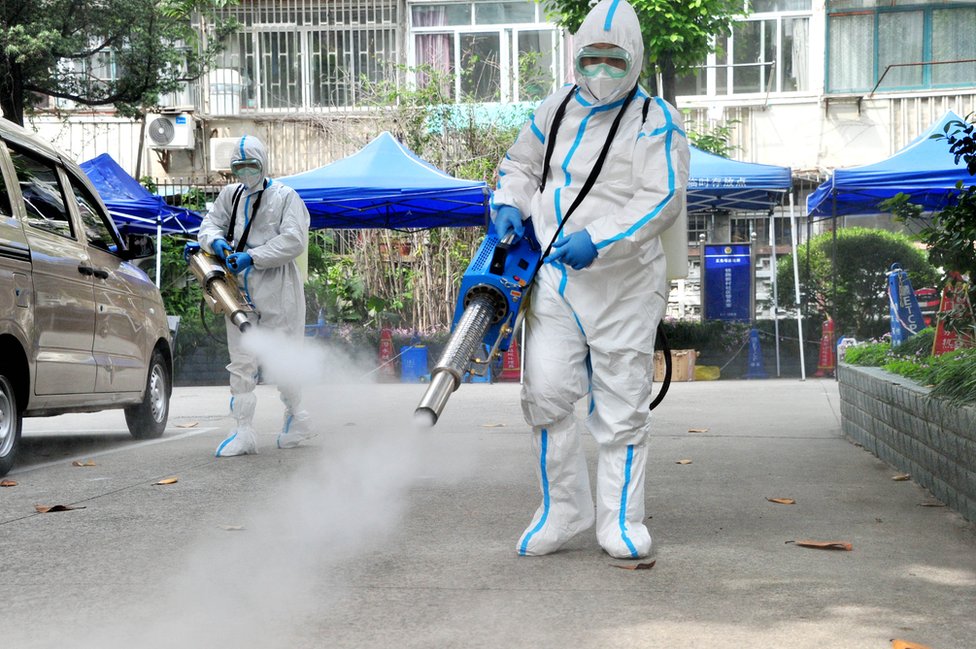 Kina i korona virus: Kako će izmučeni Šangaj konačno izaći iz karantina 2 Staff members wearing personal protective equipment (PPE) disinfect a residential community on 2 May, 2022 in Shanghai, China
