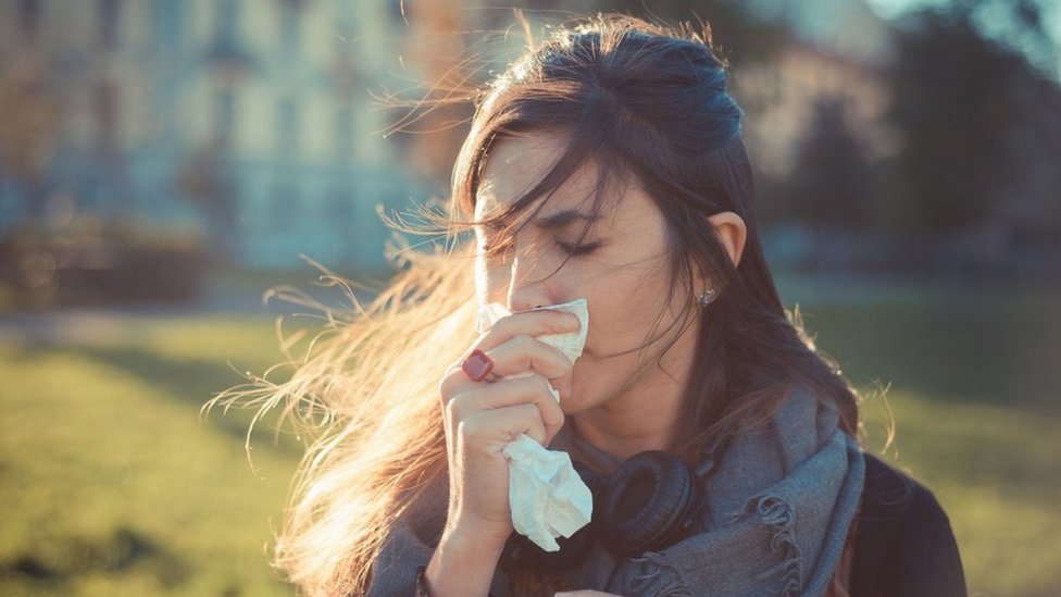Woman holding a tissue to her nose