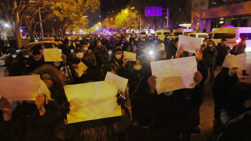 Demonstrators hold up white paper at at protest in Shanghai on 27/11