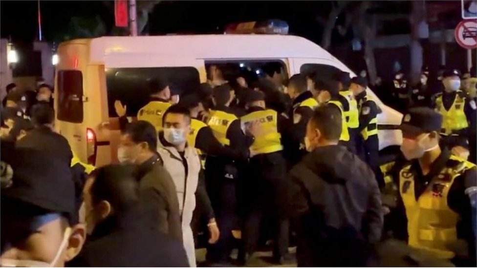 Kina i korona virus: Demonstracije pokreću mladi 3 Police officers detain people during a protest against coronavirus disease (COVID-19) curbs at the site of a candlelight vigil for victims of the Urumqi fire, in Shanghai, China in this screengrab obtained from a video released on November 27, 2022.