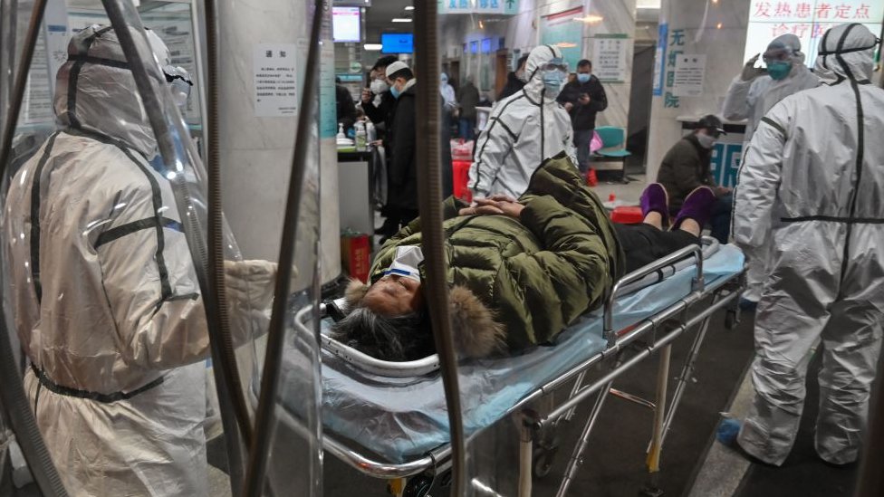 Kina i korona virus: „Ne plašim ih se“ - majka koja je izgubila ćerku od kovida sada je pod nadzorom vlasti 2 Medical staff members wearing protective clothing to help stop the spread of a deadly virus which began in the city, arrive with a patient at the Wuhan Red Cross Hospital in Wuhan on January 25, 2020.