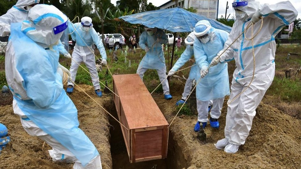 Radnici koji nose zaštitnu opremu sahranjuju dobrovoljca civilne odbrane koji je preminuo od kovida na groblju u provinciji Narathivat 24. februara 2022.