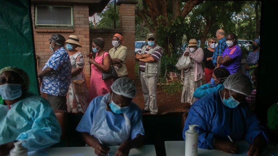 Stariji ljudi čekaju u redu za vakcinaciju Sinofarm ispred šatora, dok medicinske sestre obavljaju svoje dužnosti u lokalnoj bolnici 29. marta 2021. u Harareu, Zimbabve