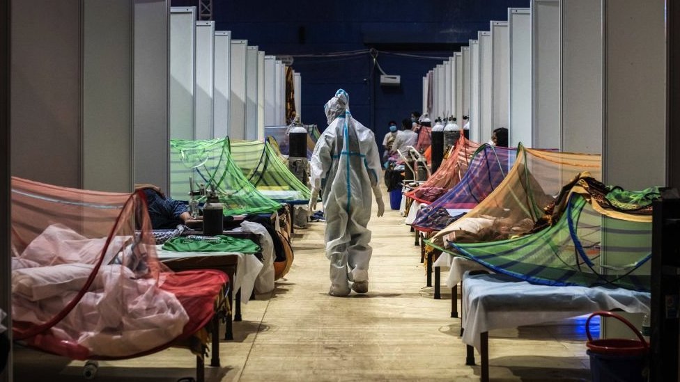 Pandemijski sporazum SZO: Kako svet pokušava da izbegne ponavljanje „vakcinalnog aparthejda“ tokom kovida 5 Medicinski radnik u PPE posmatra pacijente koji su zaraženi Covid-19 u improvizovanoj ustanovi za negu na sportskom stadionu u Komonvelt Gejms Vilidž u Nju Delhiju 2. maja 2021.
