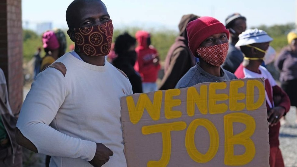 Demonstranti pokazuju plakat u blizini rudarske zajednice Seraleng 18. maja 2020. u Rustenburgu, Južna Afrika
