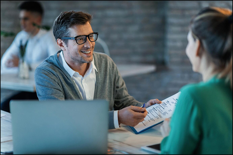 happy businessman talking his colleague while going through financial reports office 637285 1043